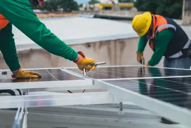 Roofer fixing sheets down by hand on a roof