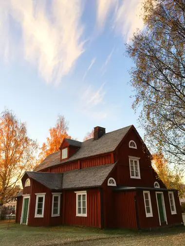 Character home with a steep roof under a dramatic storm sky