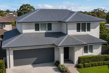 Two-storey stucco home with a fresh grey standing-seam steel roof